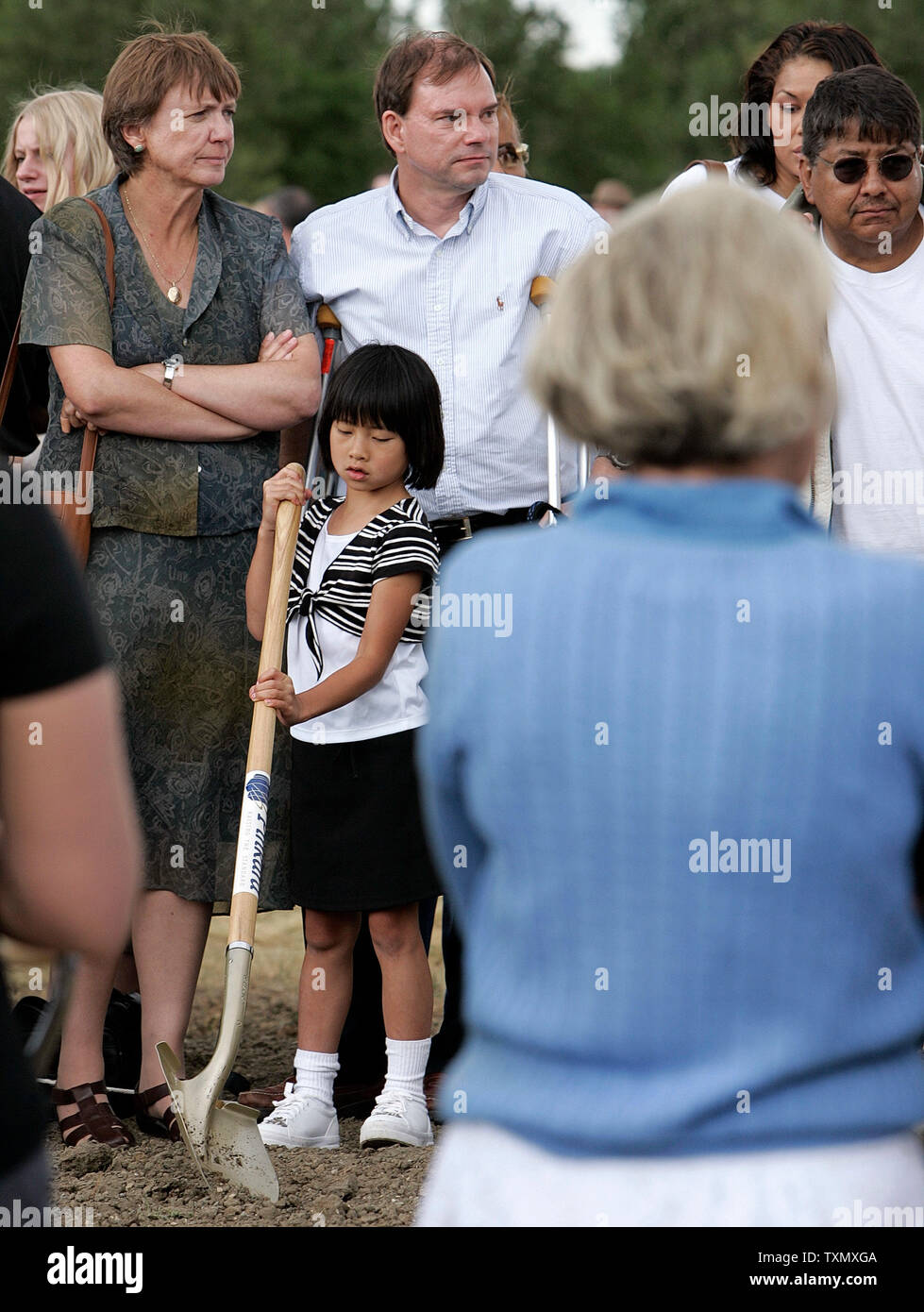 Tom Mauser (C) stands next to his adopted daughter Madeline HaiXing Mauser (bottom) at the official Columbine memorial groundbreaking ceremony at Clement Park in Littleton, Colorado June 16, 2006.  Mauser's son Daniel was shot and killed during the Columbine massacre.  Former President Bill Clinton spoke at the groundbreaking ceremony to help raise the remaining money for the $1.5 million dollar memorial.  The Columbine memorial will be at the base of Rebel hill near Columbine high school where on April 20, 1999, Dylan Klebold and Eric Harris terrorized the school killing one teacher and twelv Stock Photo