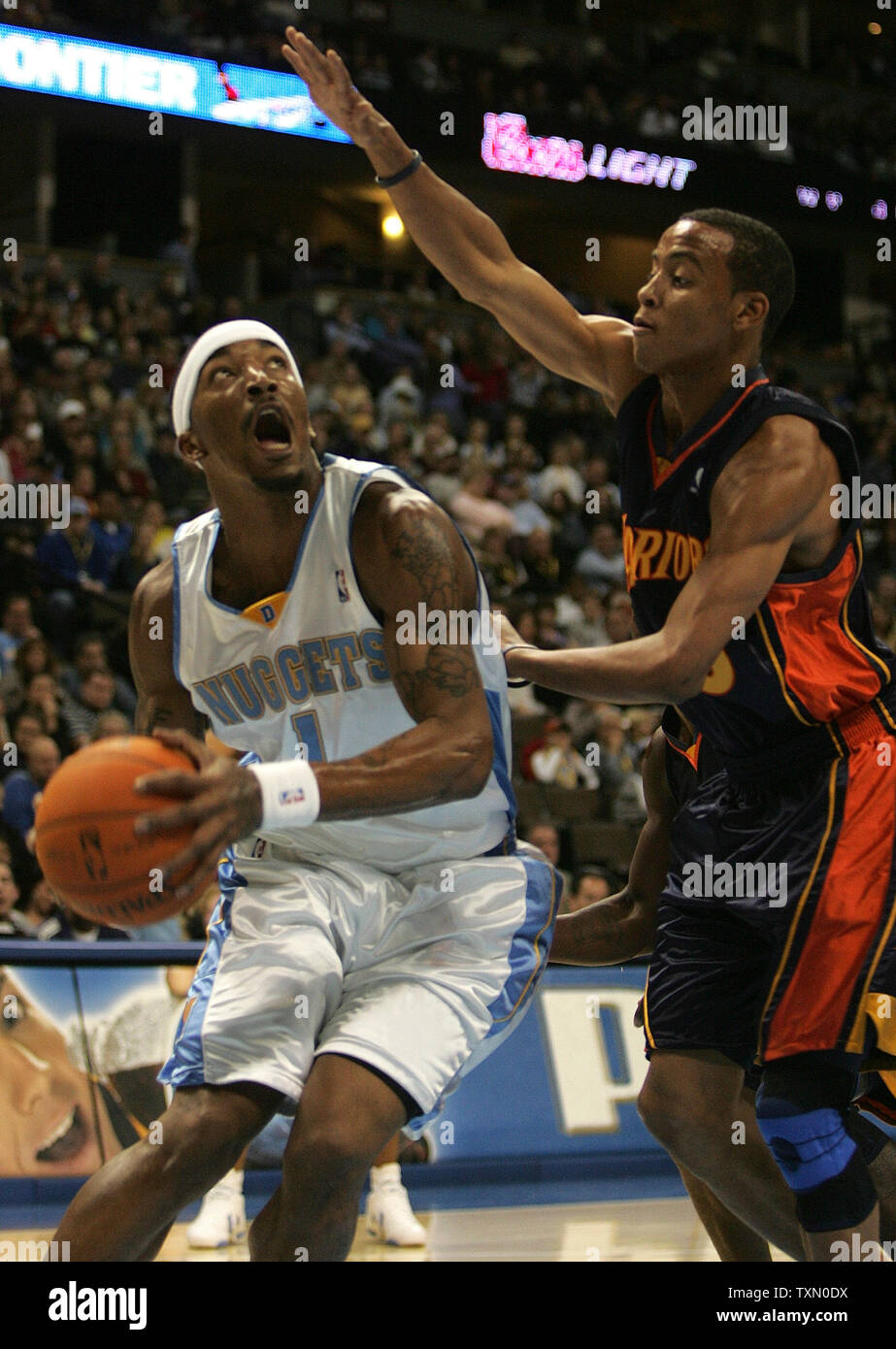 Denver Nuggets J.R. Smith (L) looks to score against Golden State Warriors Monta Ellis (R) during the first half of the game at the Pepsi Center in Denver on November 24, 2006.  Smith scored 31 points leading the Nuggets to a 140-129 win over the Warriors.  (UPI Photo/Gary C. Caskey) Stock Photo