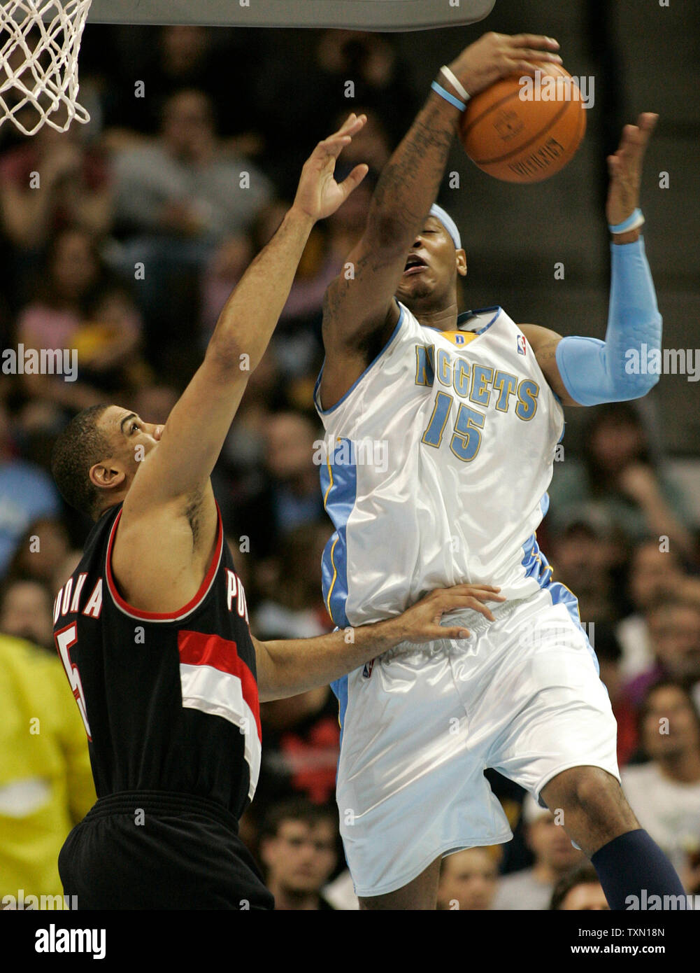 Denver Nuggets forward Carmelo Anthony (R) draws a foul from Portland Trail Blazers forward Ime Udoka in the second quarter at the Pepsi Center in Denver on March 13, 2007.  (UPI Photo/Gary C. Caskey) Stock Photo