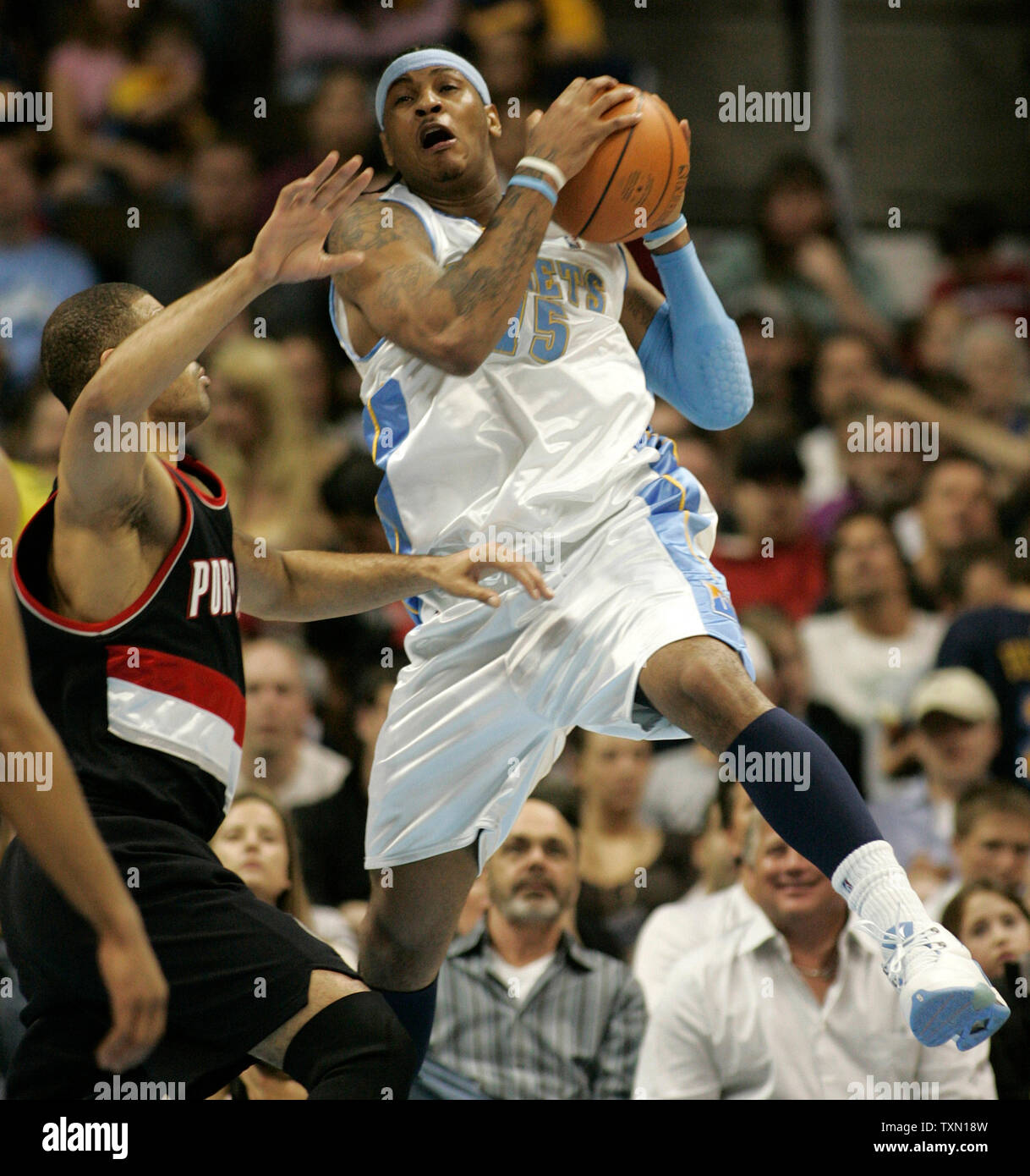 Denver Nuggets forward Carmelo Anthony (R) grabs high pass while being fouled by Portland Trail Blazers forward Ime Udoka in the second quarter at the Pepsi Center in Denver on March 13, 2007.  (UPI Photo/Gary C. Caskey) Stock Photo