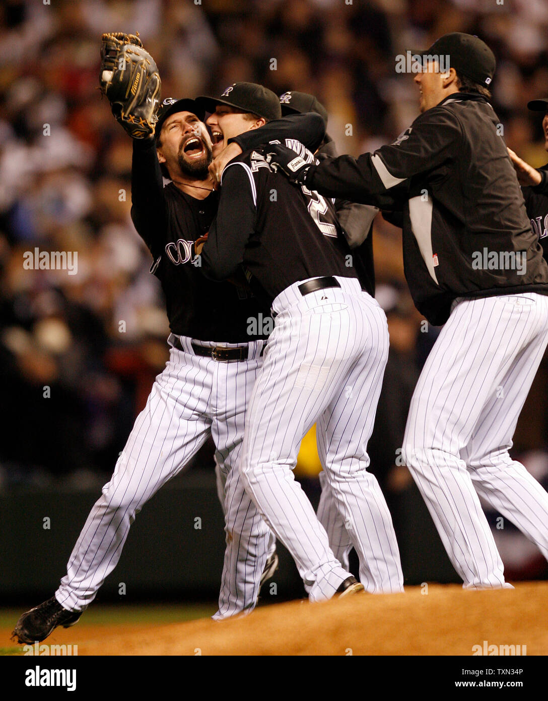 Colorado Rockies first baseman Todd Helton (L) leaps into the air with  teammate Troy Tulowitzki after beating Arizona in game four of the National  League Championship Series at Coors Field in Denver