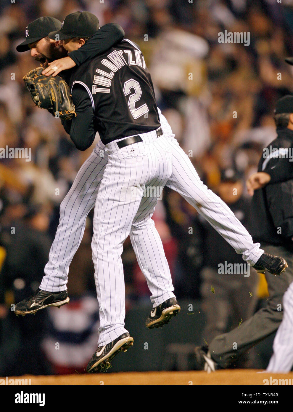 Colorado Rockies first baseman Todd Helton (L) leaps into the air with  teammate Troy Tulowitzki after beating Arizona in game four of the National  League Championship Series at Coors Field in Denver