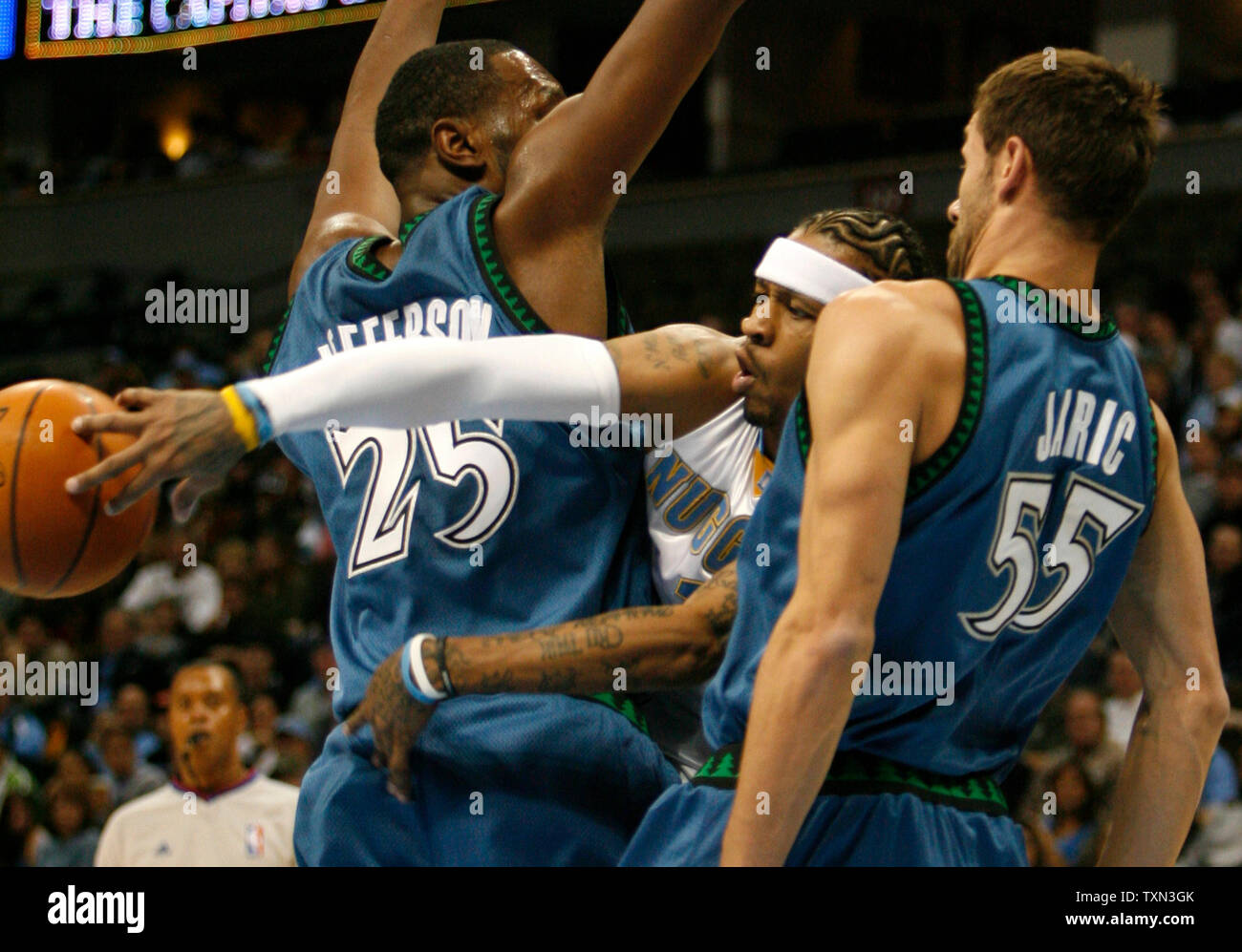 Denver Nuggets guard Allen Iverson (C) passess off after squeezing between Minnesota Timberwolves Al Jefferson (L) and Marko Jaric of Serbia in the first half at the Pepsi Center in Denver on November 23, 2007.   Denver beat Minnesota 99-93.  (UPI Photo/Gary C. Caskey) Stock Photo