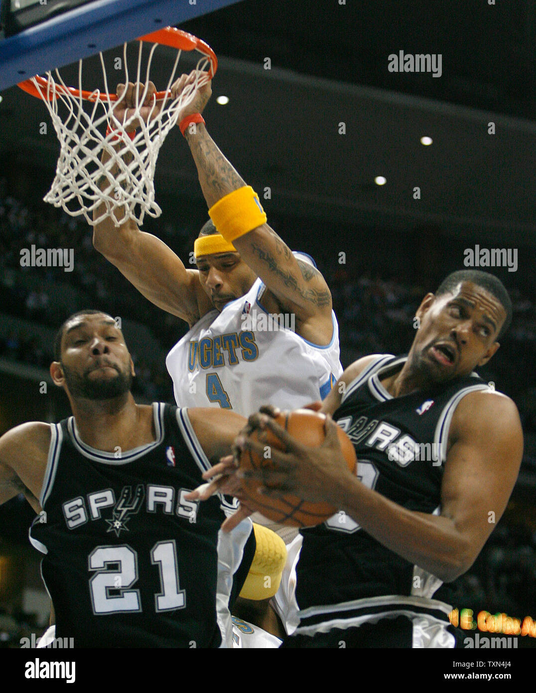 San Antonio Spurs forward Kurt Thomas (R) grabs a rebound as Spurs forward Tim Duncan and Denver Nuggets forward Kenyon Martin watch during the first quarter at the Pepsi Center in Denver on March 7, 2008.   Denver beat San Antonio 109-96.   (UPI Photo/Gary C. Caskey) Stock Photo