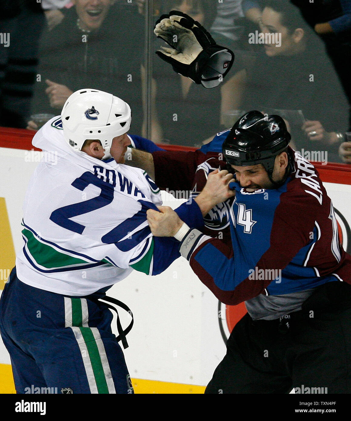 A glove flies as Vancouver Canucks left wing Jeff Cowan (L) and Colorado  Avalanche right wing Ian Laperriere fight during the first period in Denver  on March 26, 2008. Both players received