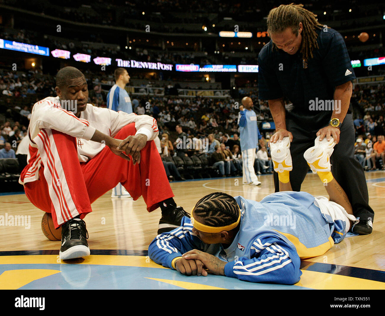Houston Rockets center Dikembe Mutombo (L) sits on a basketball chatting with Denver Nuggets guard Allen Iverson during pre-game warm ups at the Pepsi Center in Denver on April 13, 2008.  Denver kept its playoff hopes alive with a 111-94 win over Houston.   (UPI Photo/Gary C. Caskey) Stock Photo