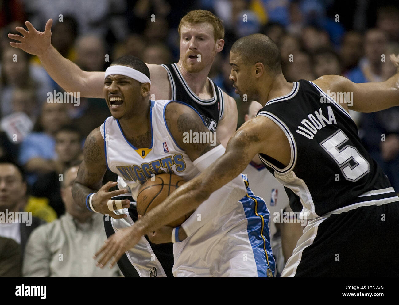 Denver Nuggets Carmelo Anthony (C) breaks free from San Antonio Spurs Matt Bonner (C) and Ime  Udoka during the second half in a matchup between division leaders at the Pepsi Center in Denver on February 3, 2009.  Denver beat San Antonio 104-96 as Spurs Tim Duncan and Tony Parker did not play.  (UPI Photo/Gary C. Caskey) Stock Photo