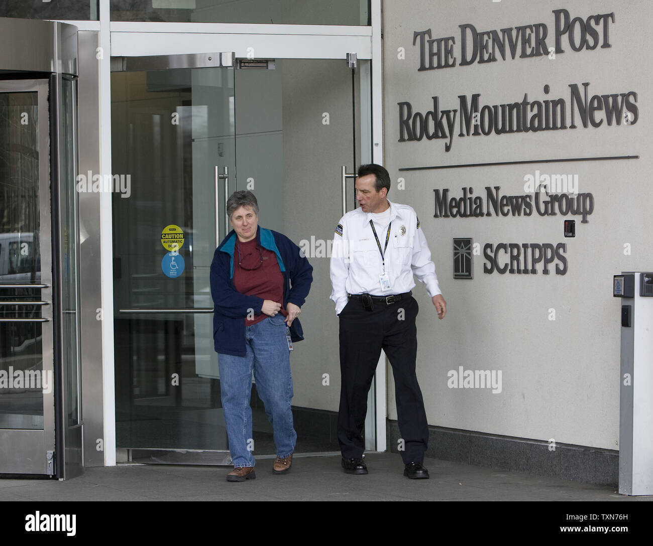 Denver Newspaper Agency Security Escorts An Employee Through The