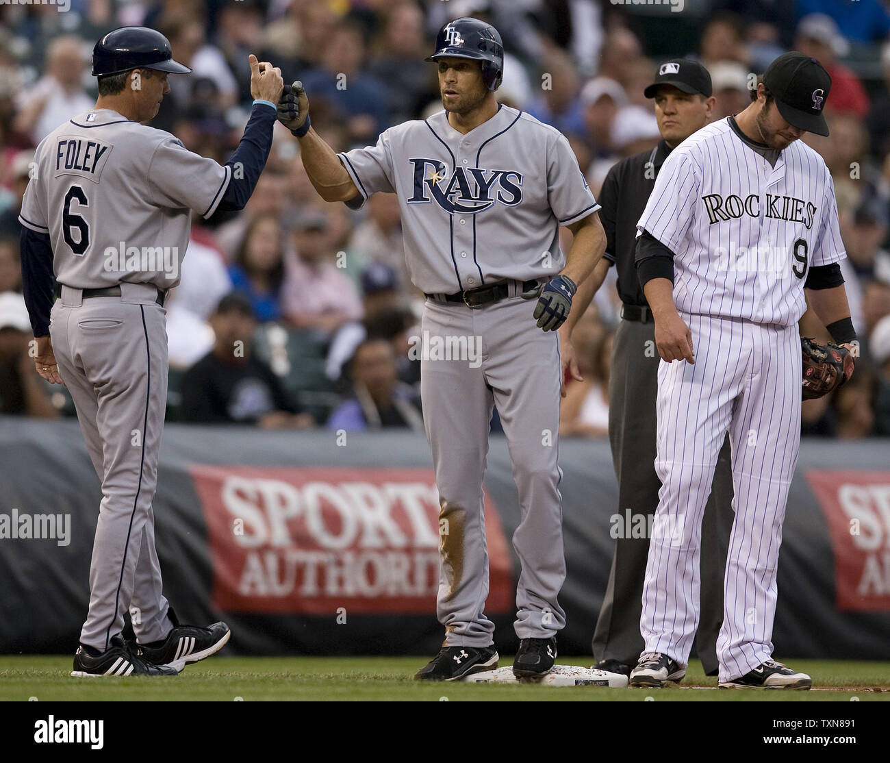 Tampa Bay Rays right fielder Gabe Kapler (C) receives congratulations from third base coach Tom Foley after a two-run triple against the Colorado Rockies in the second inning during an interleague game at Coors Field  in Denver on June 16. 2009.  Rockies third baseman Ian Stewart walks away from the celebrating duo.  Tampa Bay snapped Colorado's eleven game win streak with a 12-4 win.     (UPI Photo/Gary C. Caskey) Stock Photo