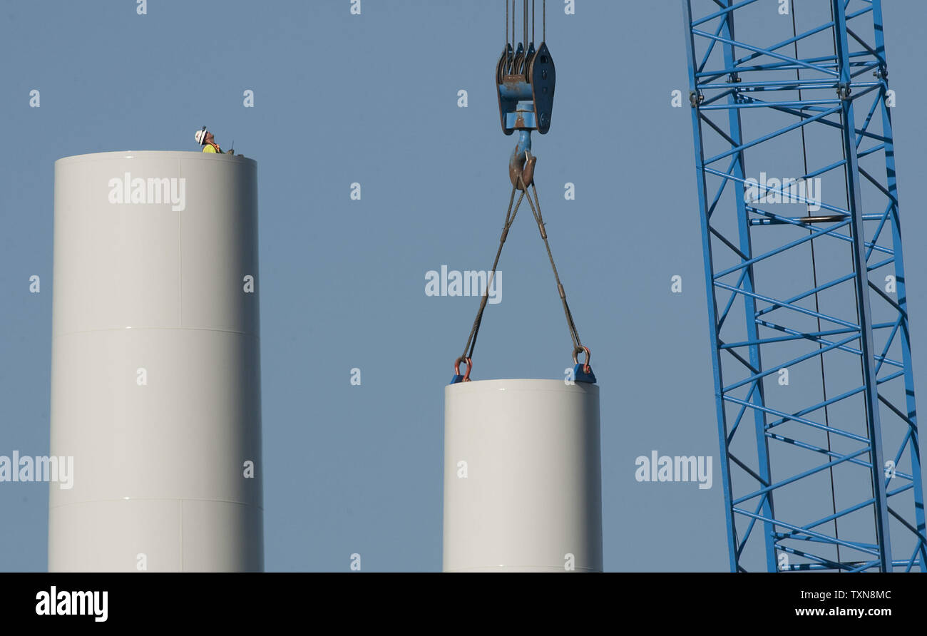 A solitary worker standing inside the lower section of a wind turbine's steel tower watches the crane operate as it brings the second section of the tower to its coupling height at the National Renewable Energy Laboratory's (NREL) National Wind Technology Center near Boulder, Colorado on August 21, 2009.  The tower will stand 262.5 feet tall before the nacelle containing the wind turbine is placed on top.       UPI/Gary C. Caskey Stock Photo
