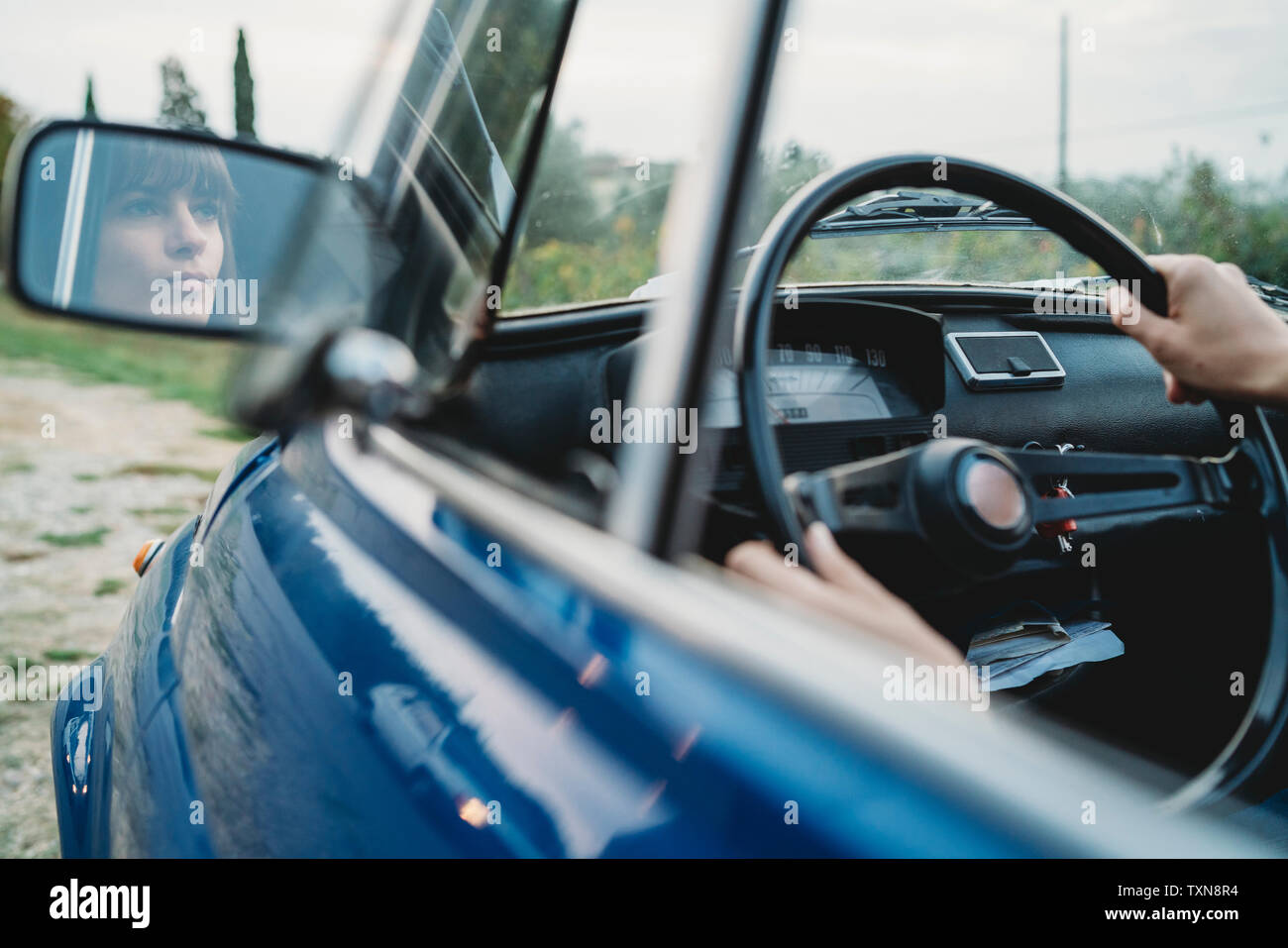 Mirror image of woman driving car Stock Photo