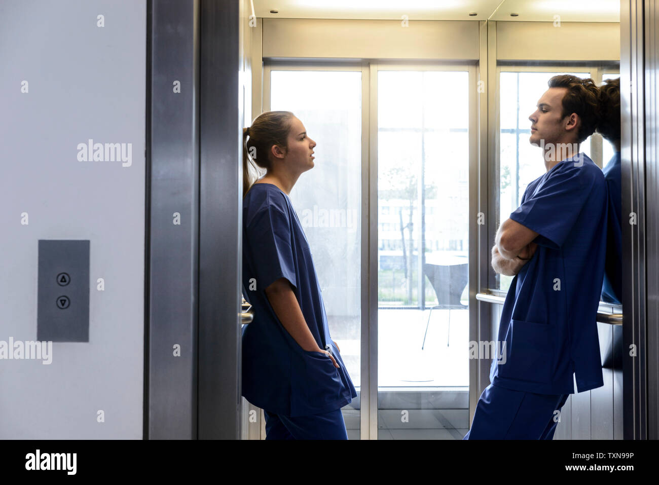 Young female and male junior doctors in hospital elevator Stock Photo