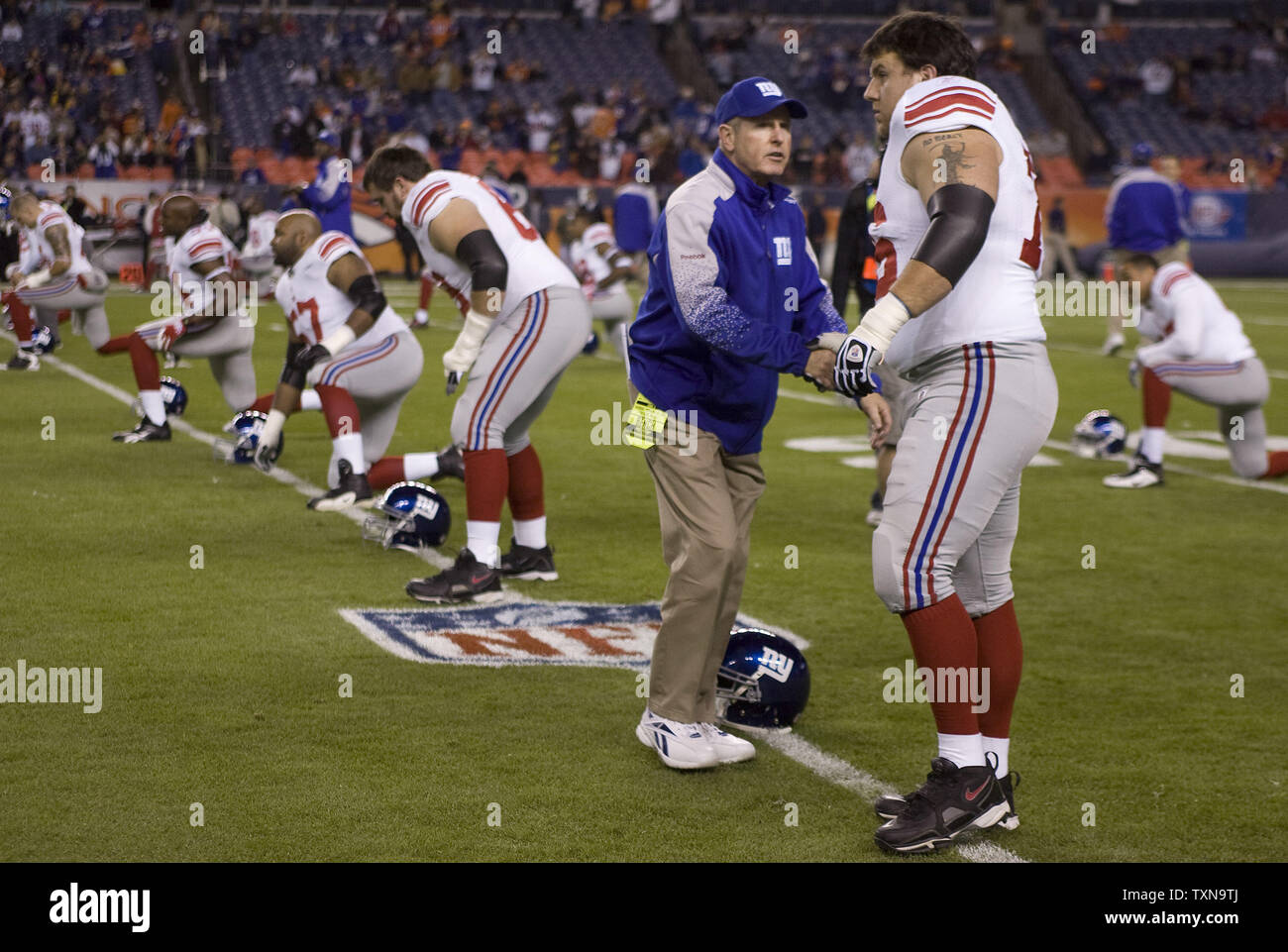 New York Giants head coach Tom Coughlin shakes hands with right guard Chris Snee during their Thanksgiving warmups at Invesco Field at Mile High in Denver on November 26, 2009.    UPI/Gary C. Caskey... Stock Photo