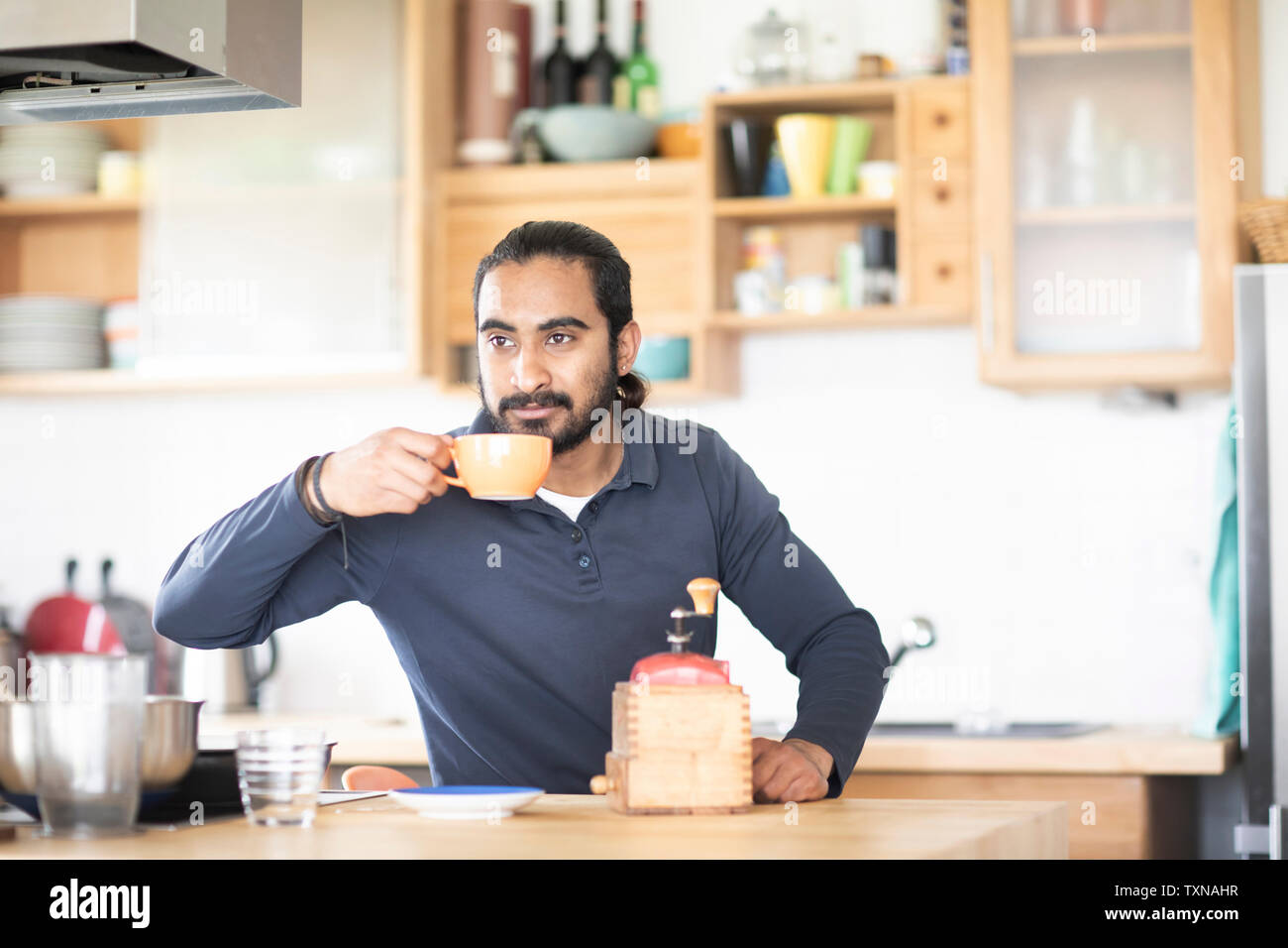 Young man at kitchen counter drinking fresh coffee Stock Photo