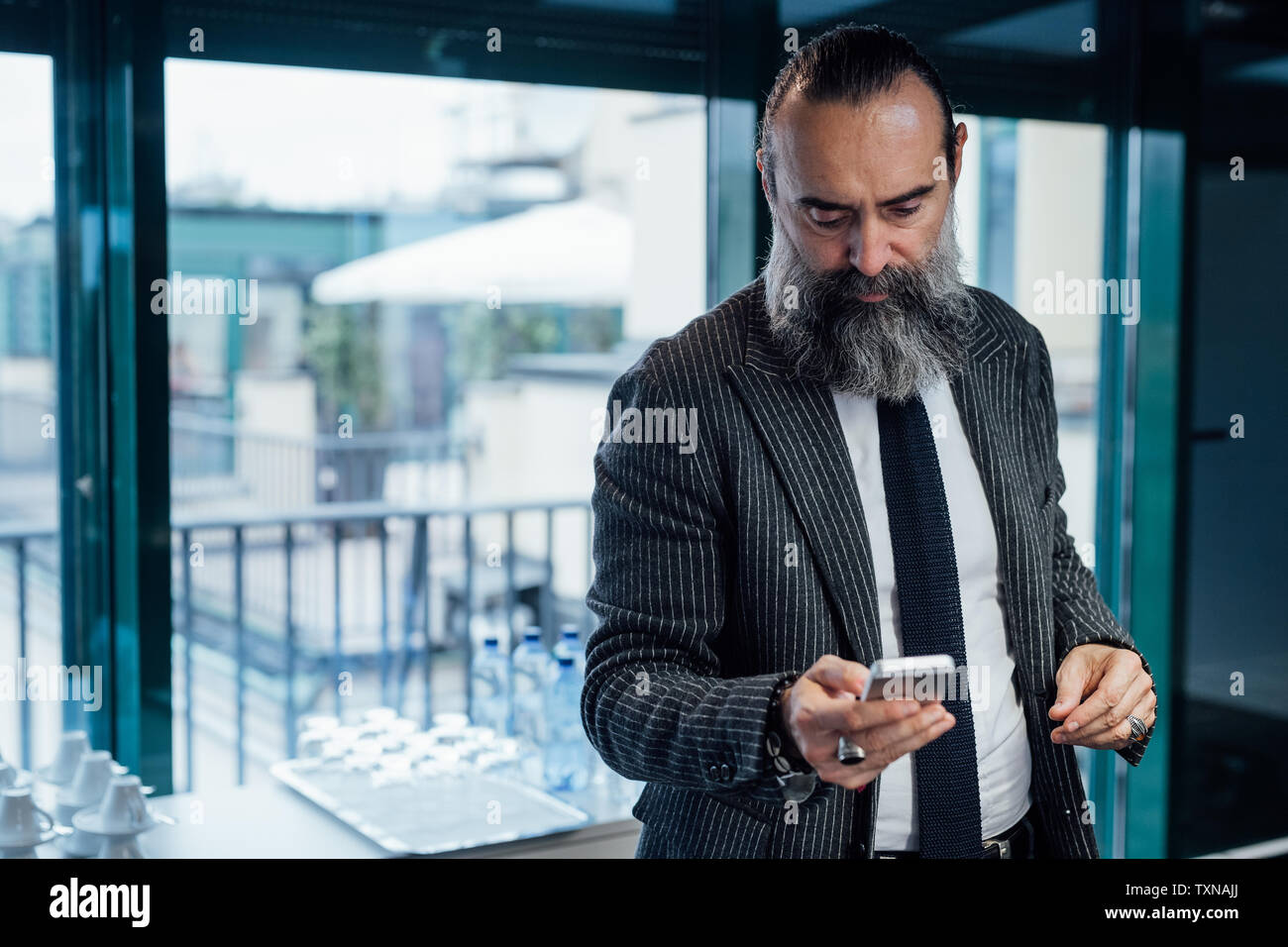 Businessman using smartphone in office Stock Photo