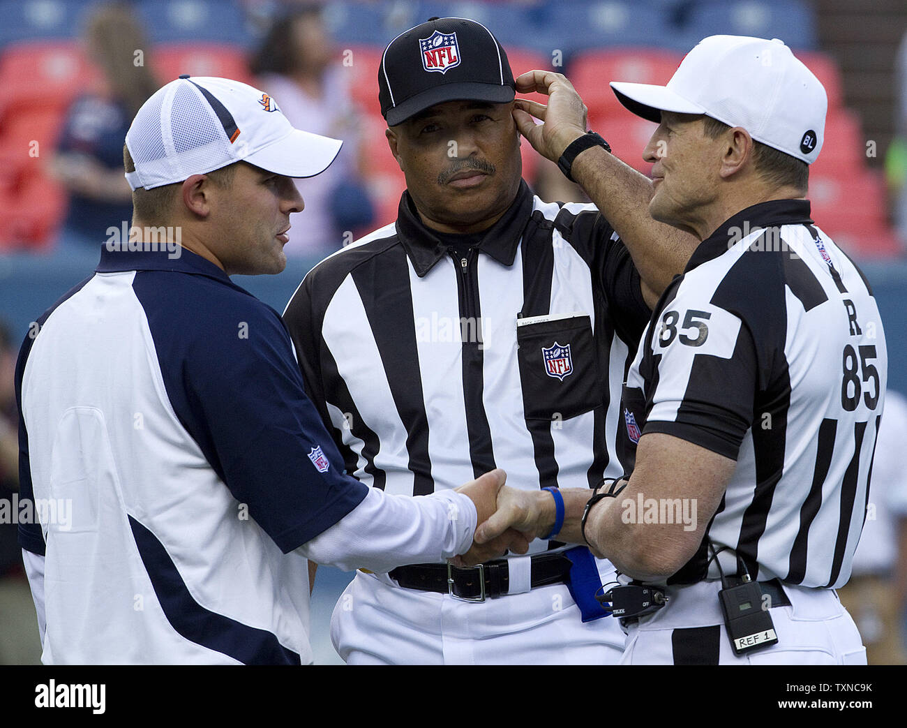 Denver Broncos head coach Josh McDaniels (L) greets referee Ed Hochuli, and back judge Don Carey (C) at Invesco Field at Mile High on August 21, 2010 in Denver.      UPI/Gary C. Caskey Stock Photo