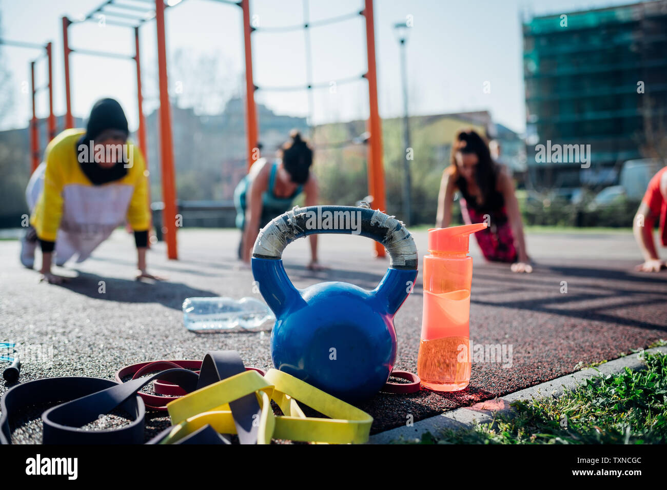 Calisthenics class at outdoor gym, young women practicing yoga position, shallow focus Stock Photo