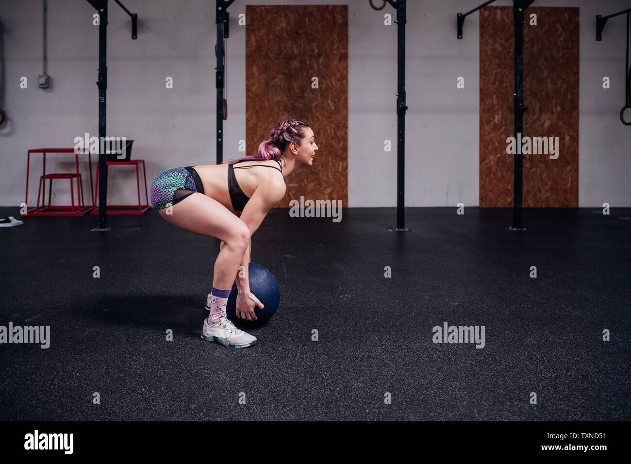 Young woman training, lifting atlas ball in gym Stock Photo - Alamy