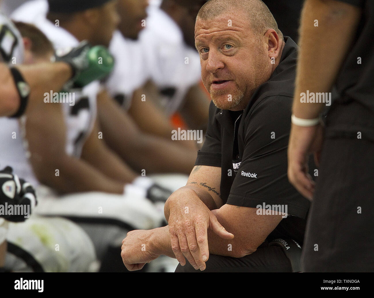 Oakland Raiders head coach Tom Cable talks to his offensive lineman during the second half at Invesco Field at Mile High on October 24, 2010 in Denver.   The Raiders decimated the Broncos 59-14.         UPI/Gary C. Caskey Stock Photo