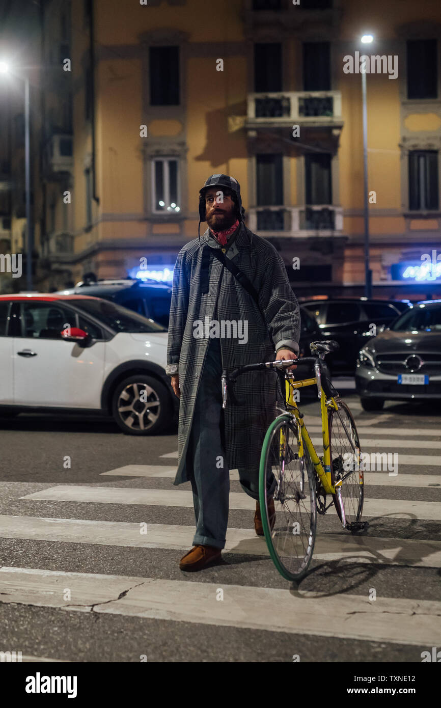 Bearded young man walking on pedestrian crossing with bicycle Stock Photo