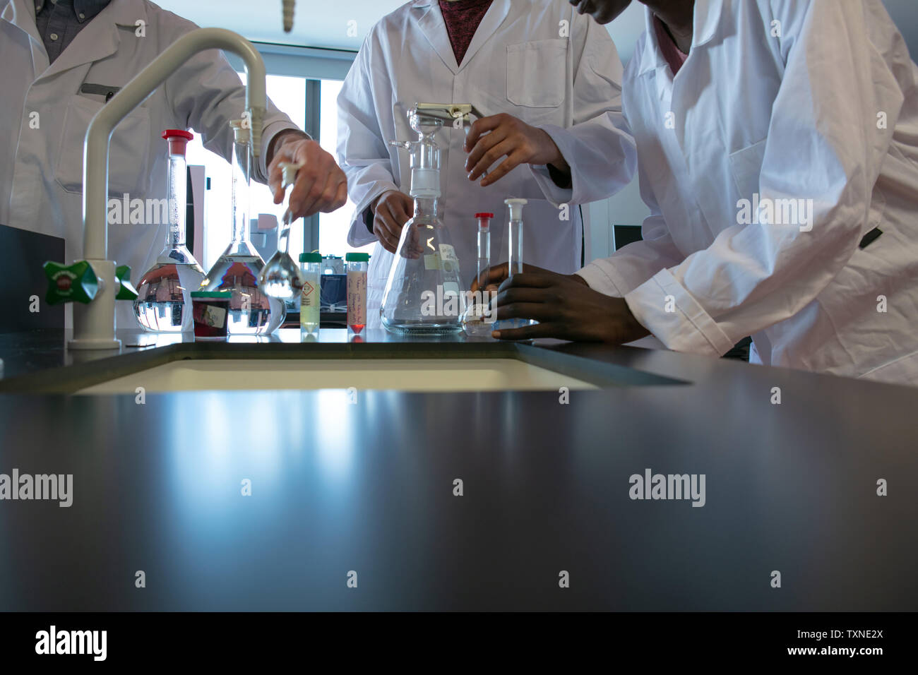 Male and female scientists preparing experiment with sample bottles in