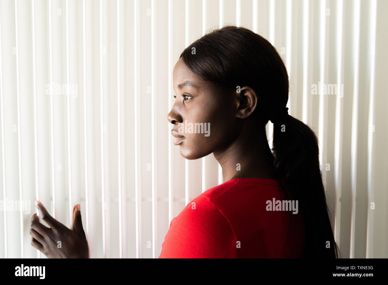 Young woman in red tshirt, head and shoulder profile portrait Stock Photo