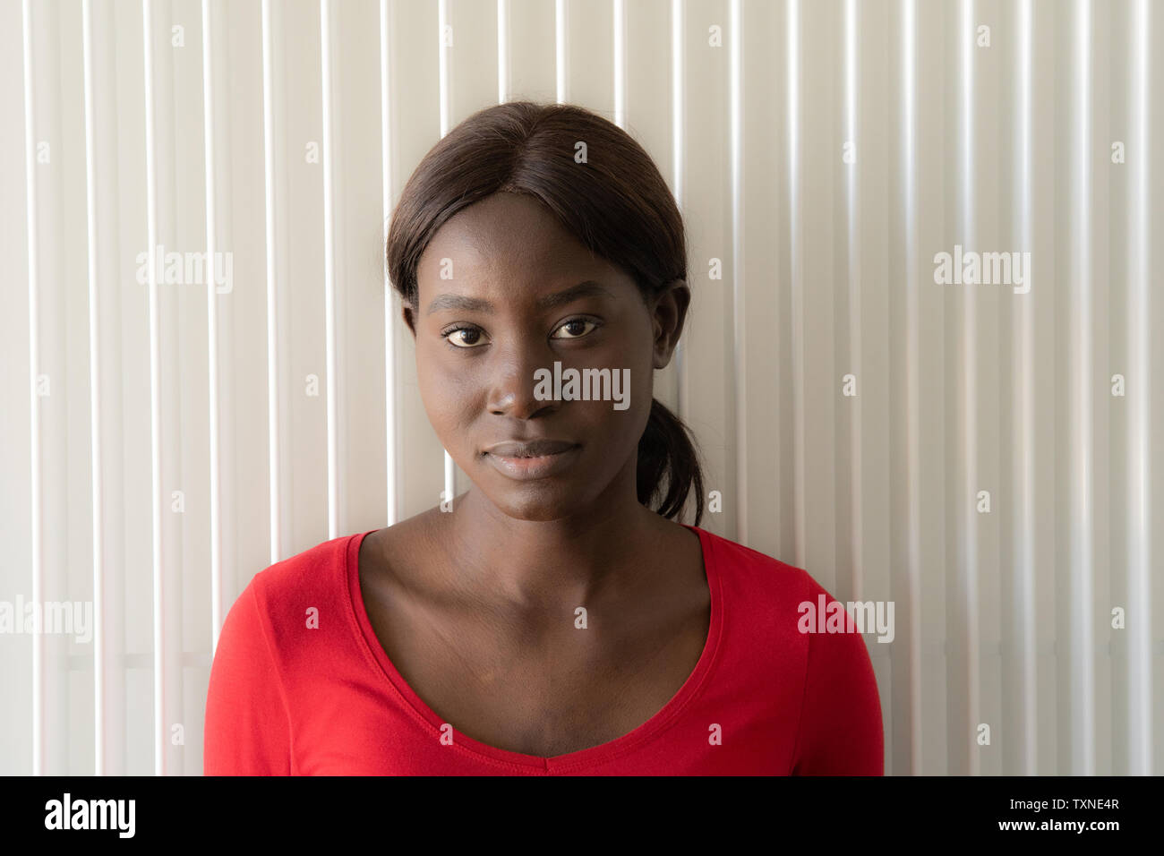 Young woman in red tshirt, head and shoulder portrait Stock Photo