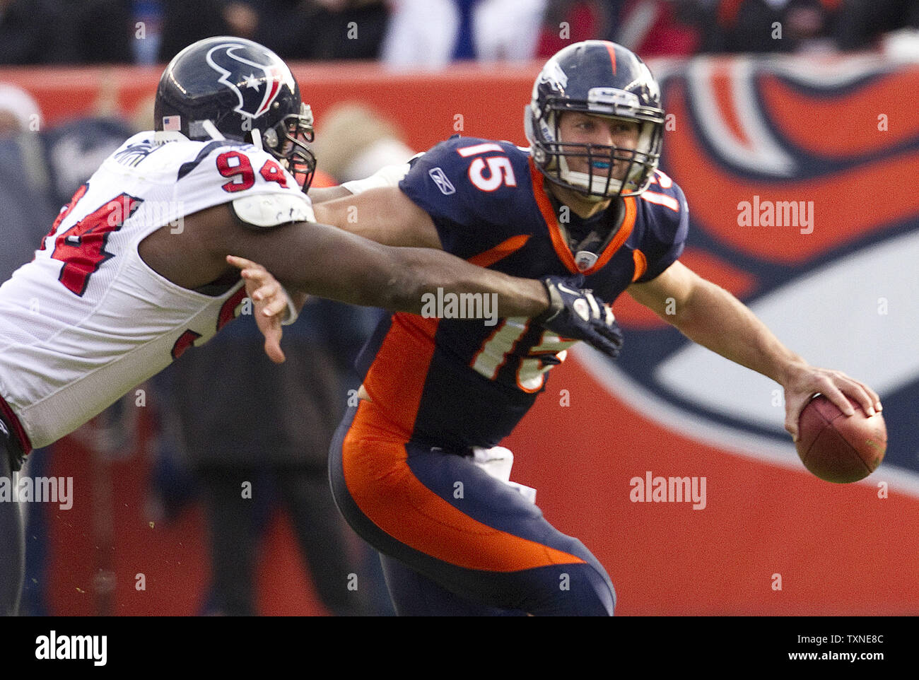 Denver Broncos rookie quarterback Tim Tebow escapes from Houston Texans defensive end Antonio Smith during the first half at Invesco Field at Mile High on December 26, 2010 in Denver.         UPI/Gary C. Caskey Stock Photo