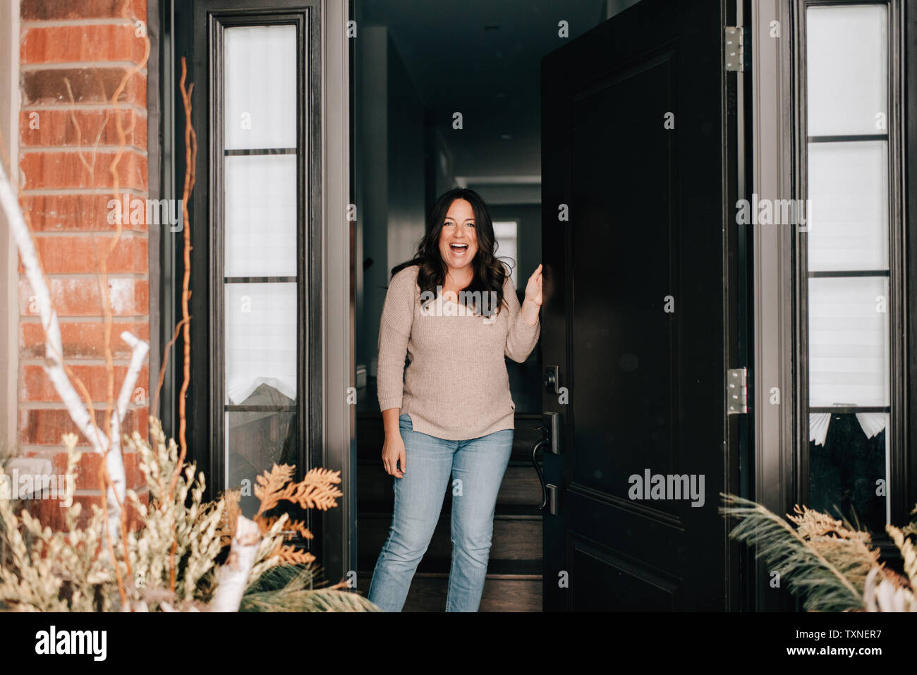 Mid Adult Woman Opening House Front Door Portrait Stock Photo