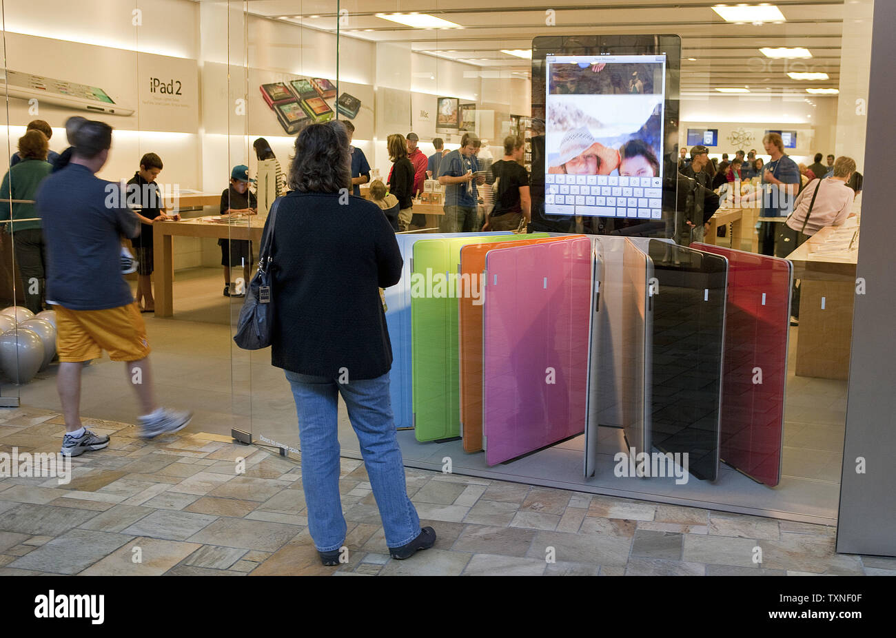 Shoppers browse the Apple storefront displays for the newly released