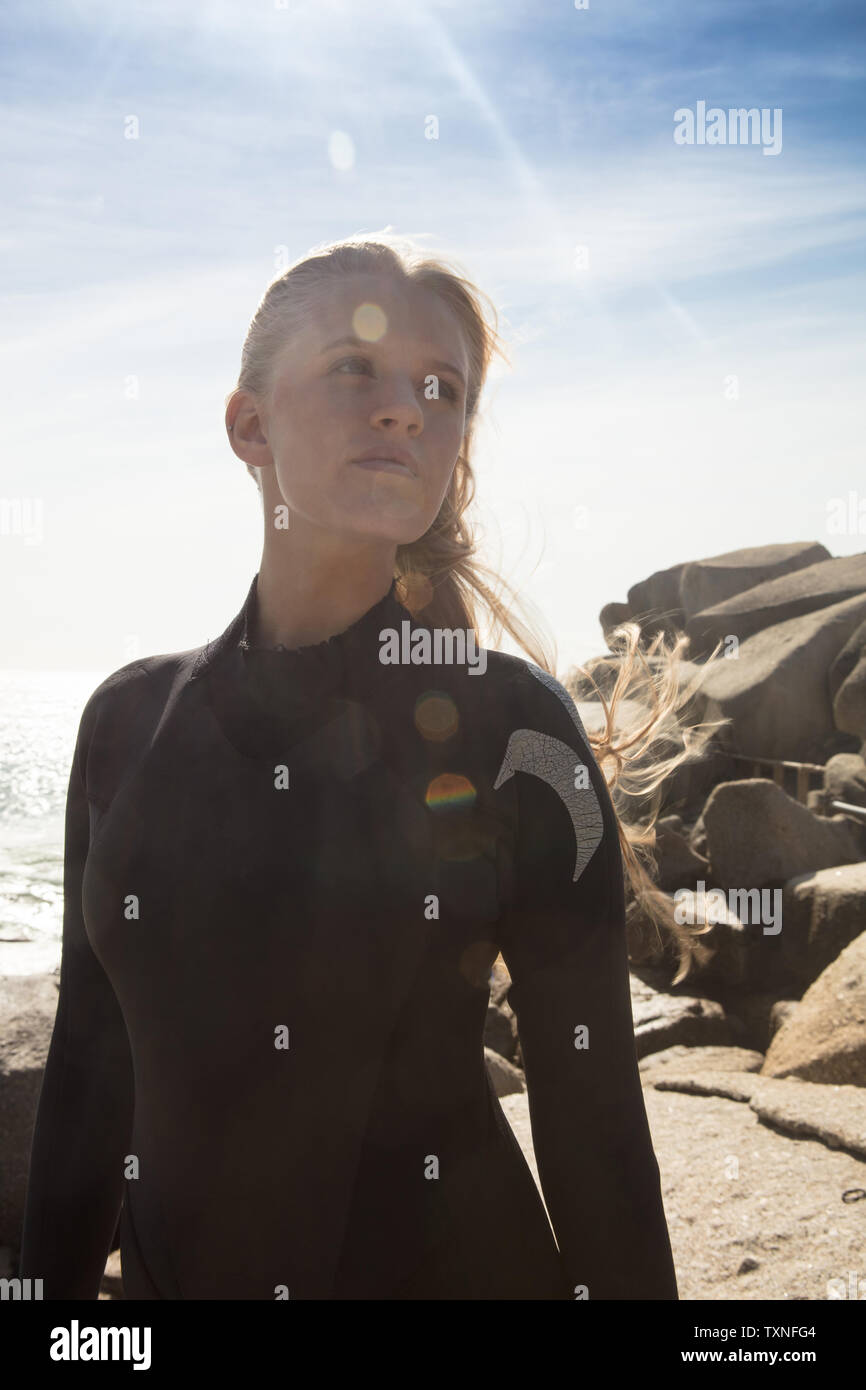 Young female surfer looking sideways on beach, Cape Town, Western Cape, South Africa Stock Photo