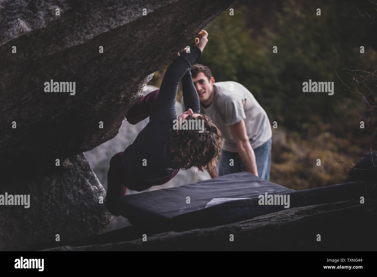 Climber bouldering, watched by friend, Squamish, Canada Stock Photo