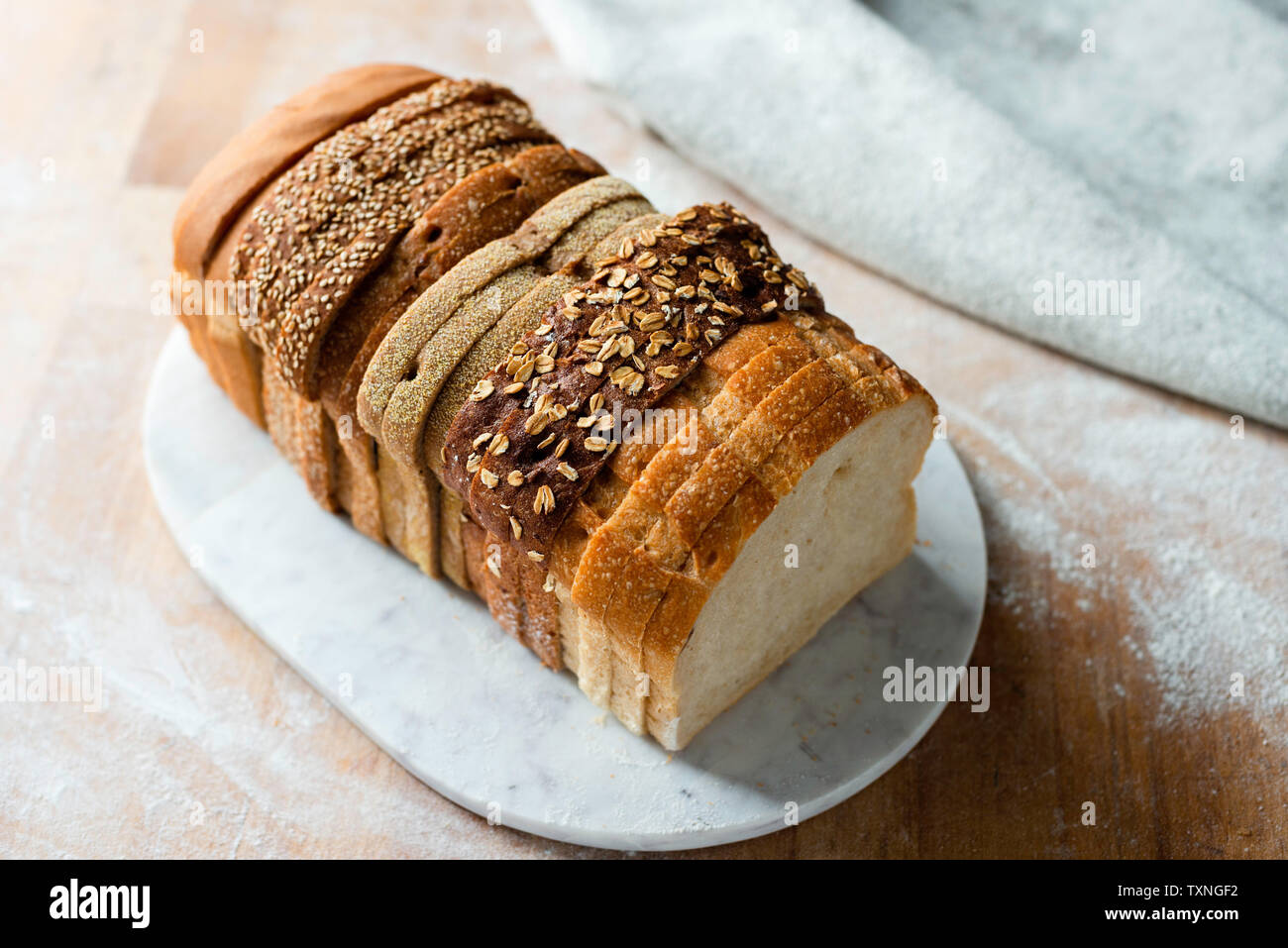 Sliced loaf made up of variety of white and wholemeal slices on cutting board, high angle view Stock Photo