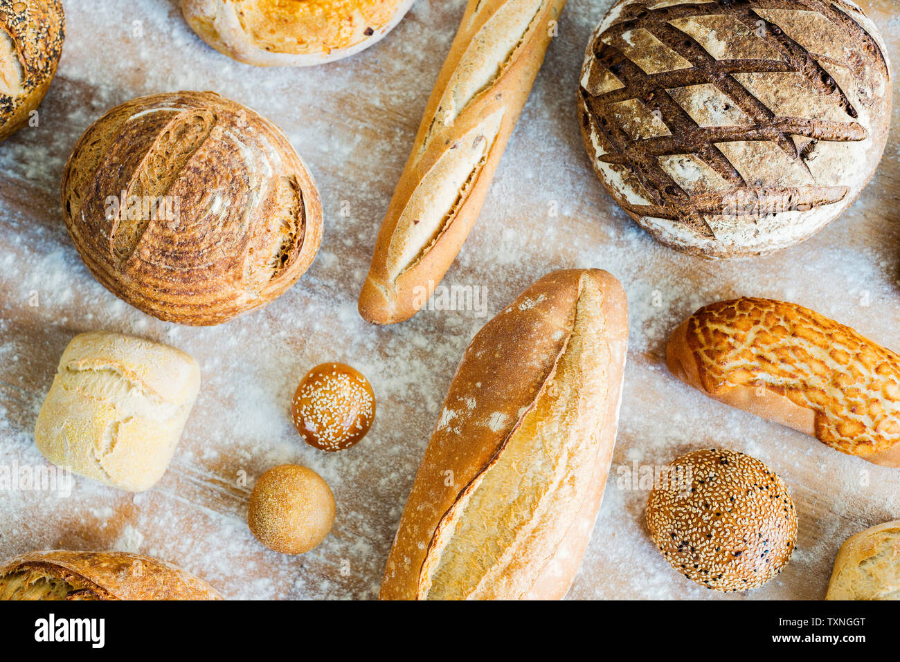 Large variety of wholemeal and white bread rolls and loaves, overhead view Stock Photo