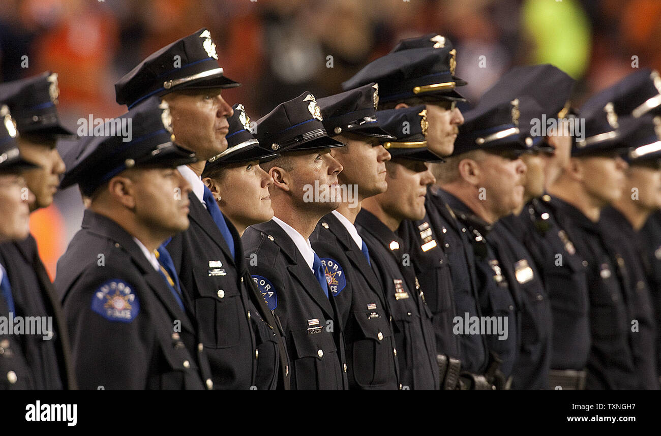 Police and Fire department officers line the field during a moment of silence for 9-11 tenth anniversary remembrances prior to the start of the Oakland Raiders-Denver Broncos game at Sports Authority Field at Mile High on September 12, 2011 in Denver.       UPI/Gary C. Caskey Stock Photo