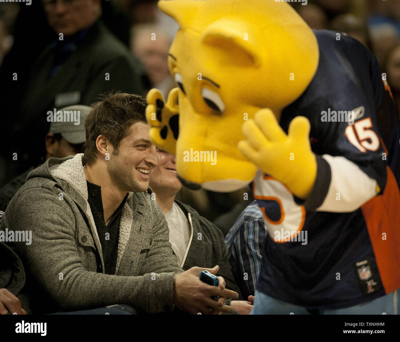 Denver Broncos quarterback Tim Tebow smiles after the Denver Nuggets mascot Rocky attempted half court shots in a Tebow jersey at the Pepsi Center on January 29, 2012 in Denver.   The Los Angeles Clippers battled to a 109-105 win over the Denver  Nuggets.     UPI/Gary C. Caskey Stock Photo