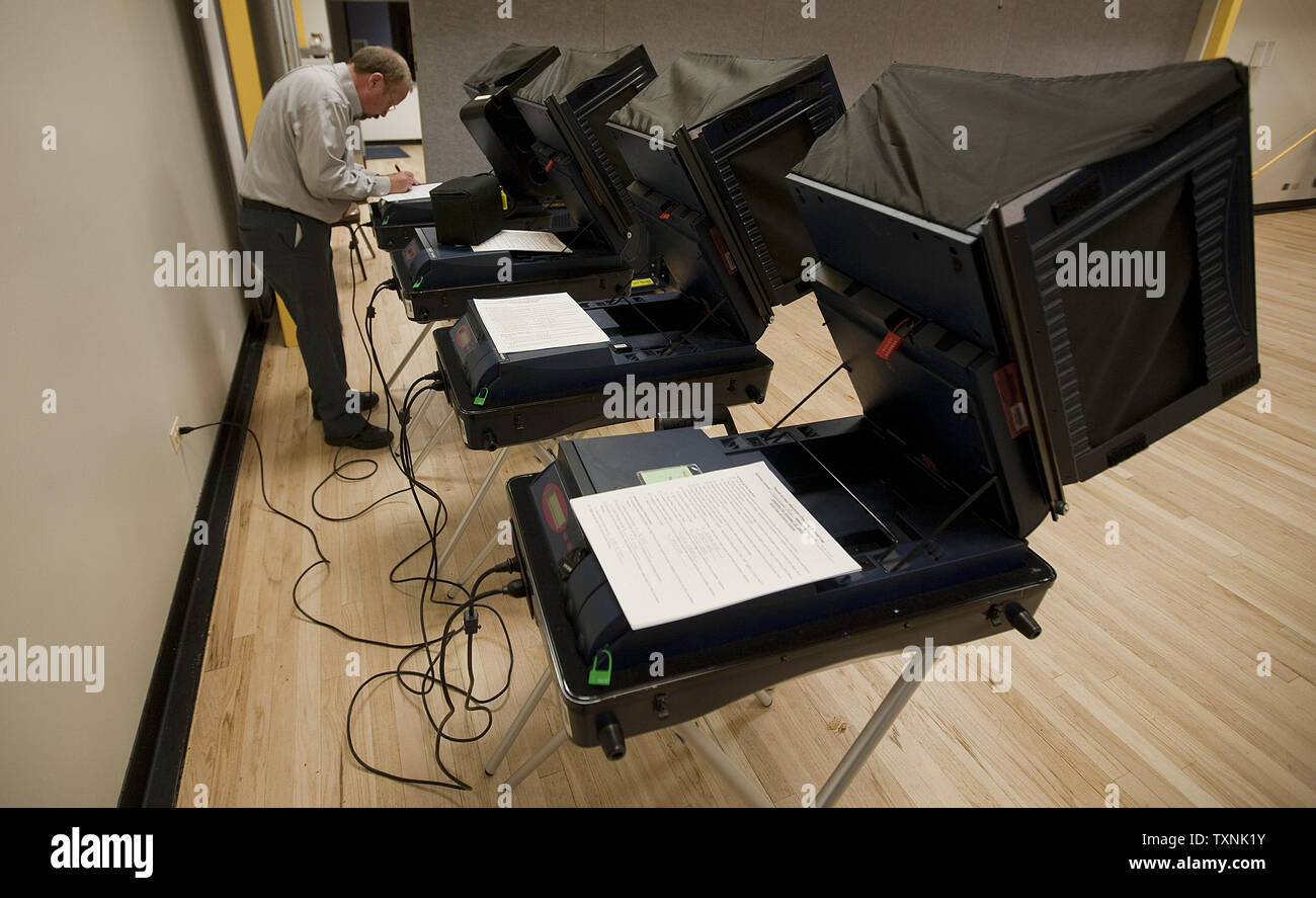 Supervisor Mark Fisher works on ballot casting machines on the first day for early voting for the 2012 presidential election in Denver on October 22, 2012.       UPI/Gary C. Caskey Stock Photo