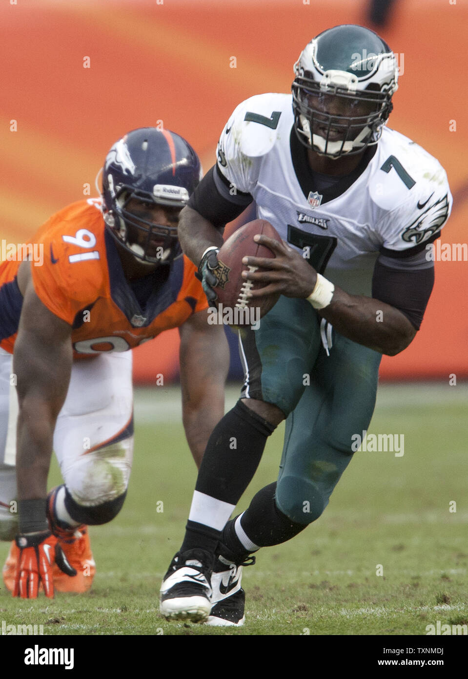 Denver Broncos Robert Ayers (91) chases Philadelphia Eagles quarterback Michael Vick out of the pocket during the third quarter at Sports Authority Field at Mile High in Denver on September 29, 2013.  Denver (4-0) beat Philadelphia (1-3) 52-20 to remain undefeated.     UPI/Gary C. Caskey Stock Photo