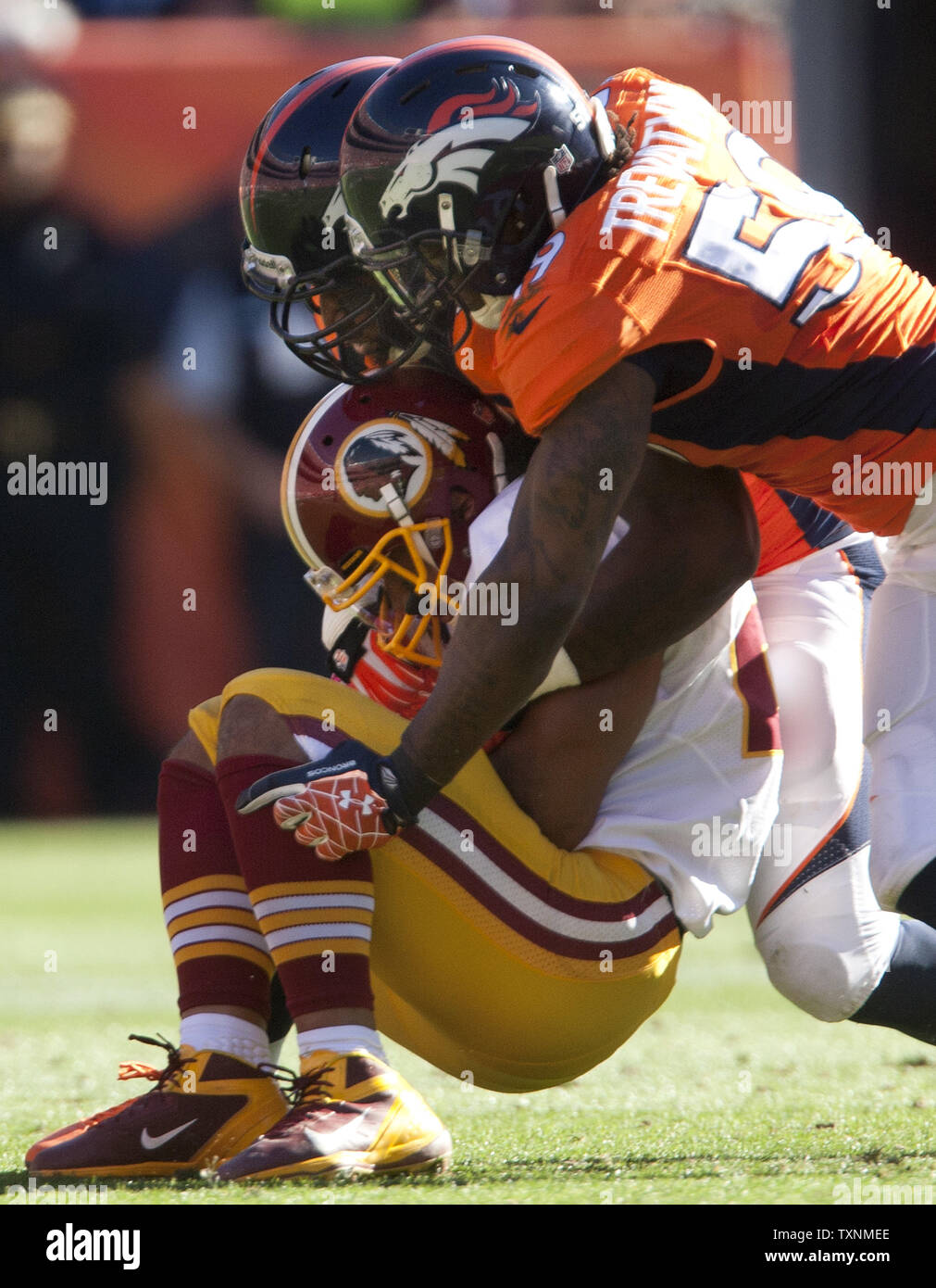 Denver Broncos Robert Ayers and Danny Trevathan tackle Washington Redskins running back Roy Helu Jr. after he picked up a Redskins fumble during the first quarter at Sports Authority Field at Mile High in Denver on October 27, 2013.     UPI/Gary C. Caskey Stock Photo