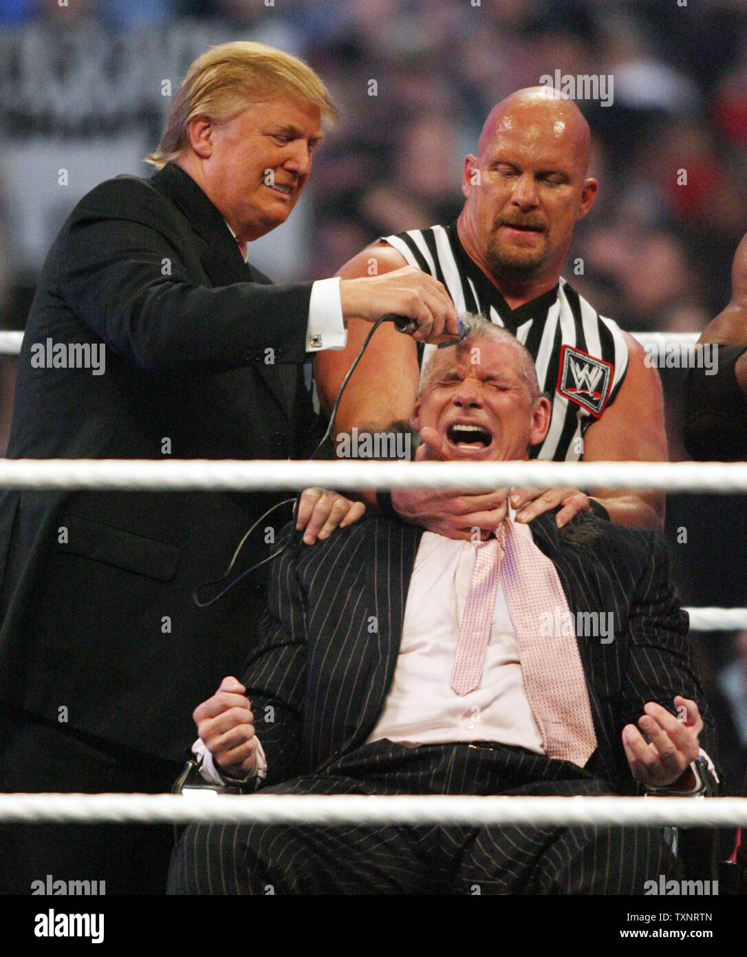 Donald Trump (L) shaves Vince McMahon's head while referee Stone Cold Steve Austin holds his head following the Battle of the Billionaires match during Wrestlemania 23 at Ford Field in Detroit on April 1, 2007.  Trumps wrestler, Bobby Lashley, defeated McMahon's wrestler Umaga.  (UPI Photos/Scott R. Galvin) Stock Photo