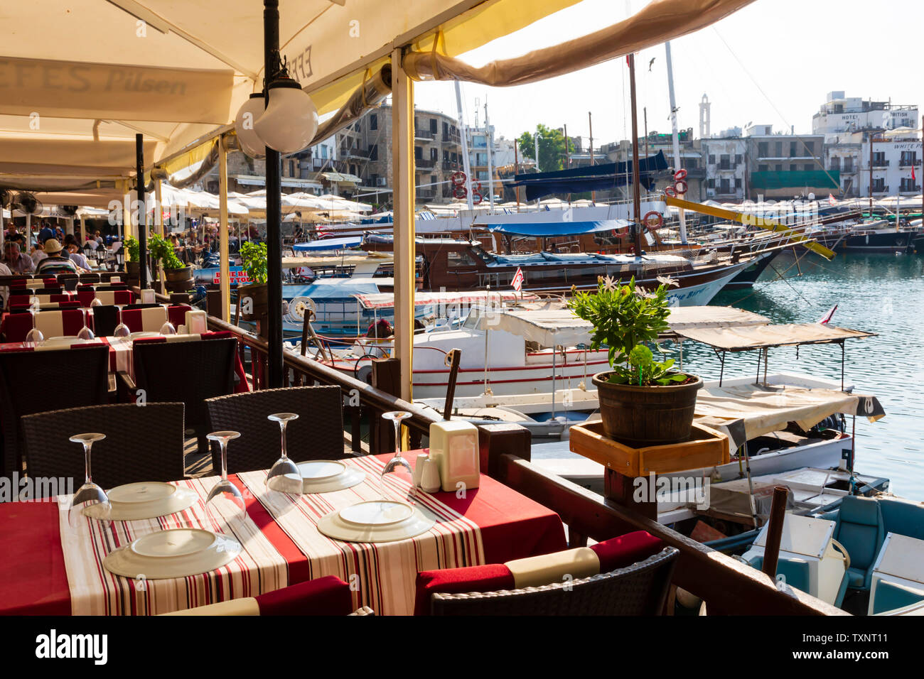 Harbour side restaurant tables, Kyrenia, Girne, Turkish Republic of Northern Cyprus. Stock Photo