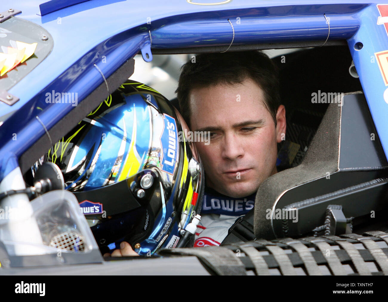Nascar driver Jimmie Johnson puts his helmet on prior to the start of