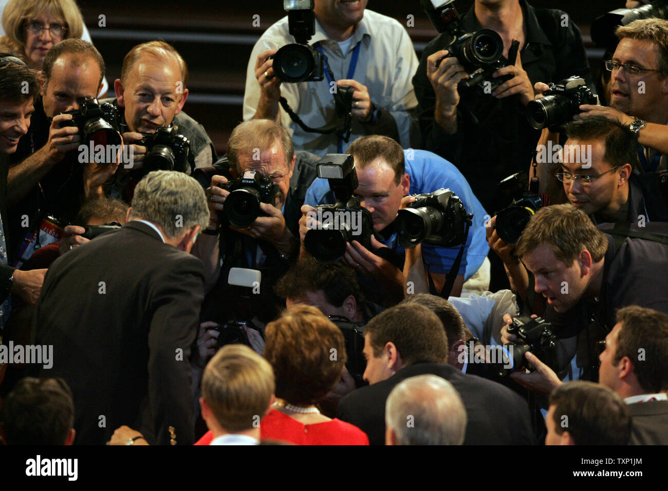 Photographers take pictures of former Mass. Gov. Michael Dukakis, left, and his wife Kitty, in the red dress, at the Democratic National Convention at the FleetCenter in Boston on July 28, 2004.  (UPI Photo/Terry Schmitt) Stock Photo