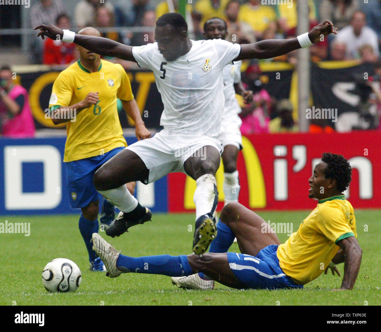 Ghana's John Mensah jumps over Ze Roberto from Brazil in World Cup soccer action in Dortmund, Germany on June 27, 2006.  Brazil beat Ghana 3-0.   (UPI Photo/Arthur Thill) Stock Photo