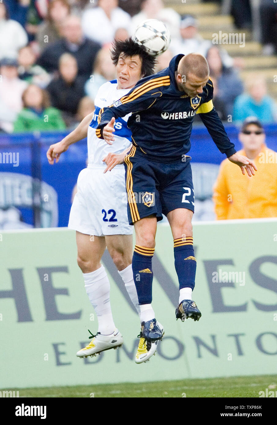 David Beckham (R) of the LA Galaxy heads the ball beside Vancouver Whitecaps Takashi Hirano from Japan during the first half of an exhibition soccer game at Commonwealth Stadium in Edmonton, Alberta, on May 13, 2008.  (UPI Photo/Heinz Ruckemann) Stock Photo