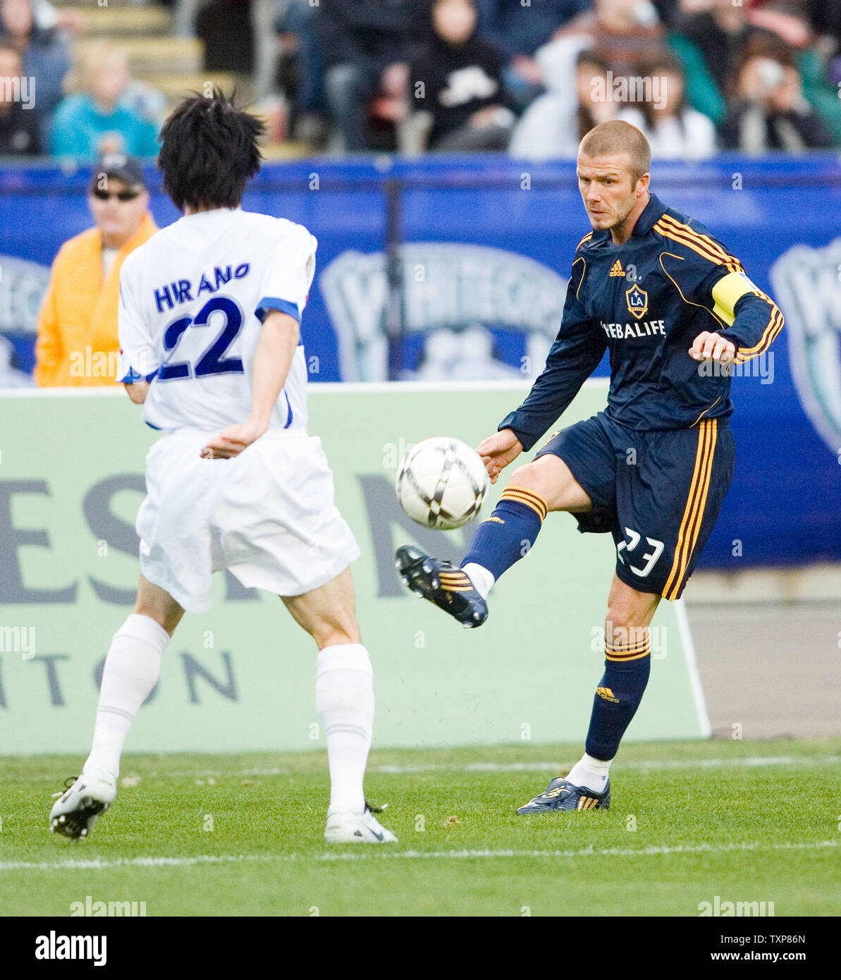 David Beckham (R) of the LA Galaxy kicks the ball past Vancouver Whitecaps Takashi Hirano from Japan during the first half of an exhibition soccer game at Commonwealth Stadium in Edmonton, Alberta on May 13, 2008.  (UPI Photo/Heinz Ruckemann) Stock Photo