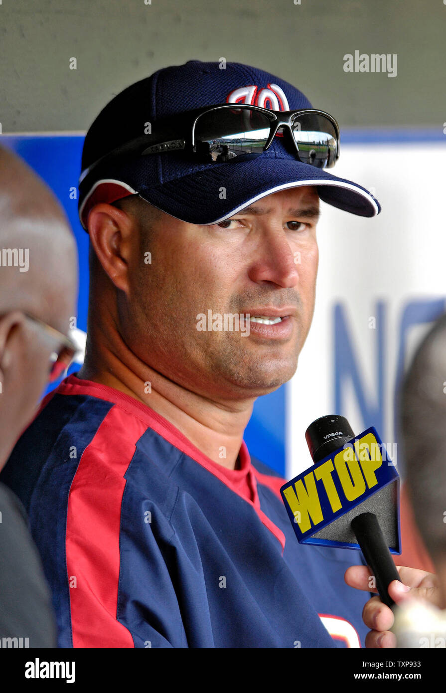 Manny Acta dons his jersey and hat after he was announced as the