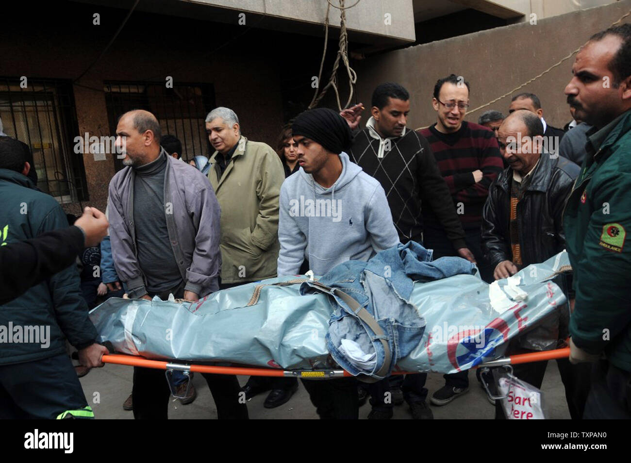 Mourners carry the body of a victim of clashes at a soccer stadium