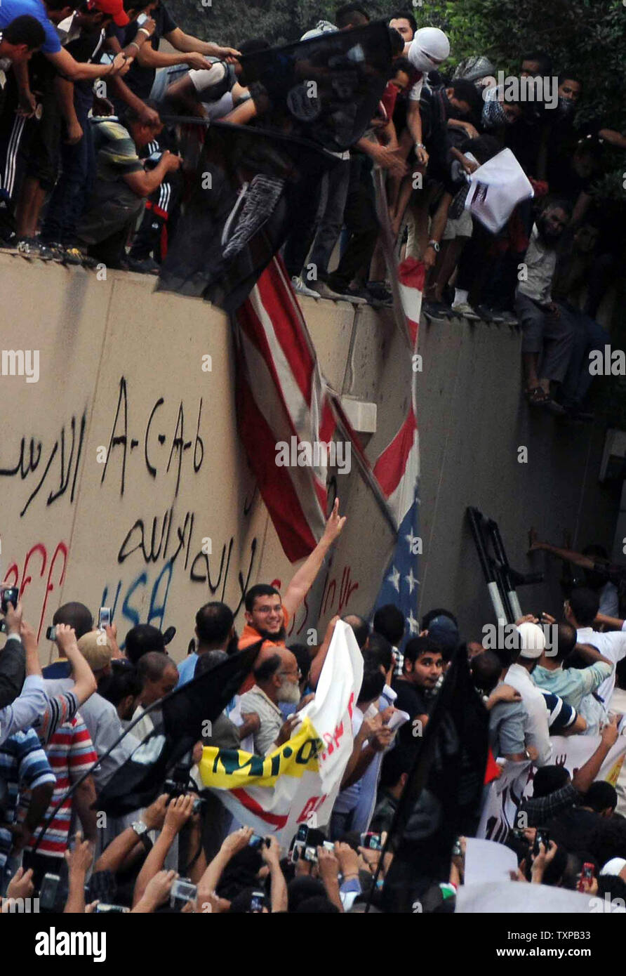Egyptian protesters tear down an American flag at the United States embassy in Cairo on September 11, 2012, during a demonstration against a film deemed offensive to Islam and the Prophet Mohammad.  In Libya, Islamic extremists killed the American ambassador as they stormed the American consulate in Benghazi in anger against the little known film by an amateur American filmmaker.  UPI/Ahmed Jomaa Stock Photo