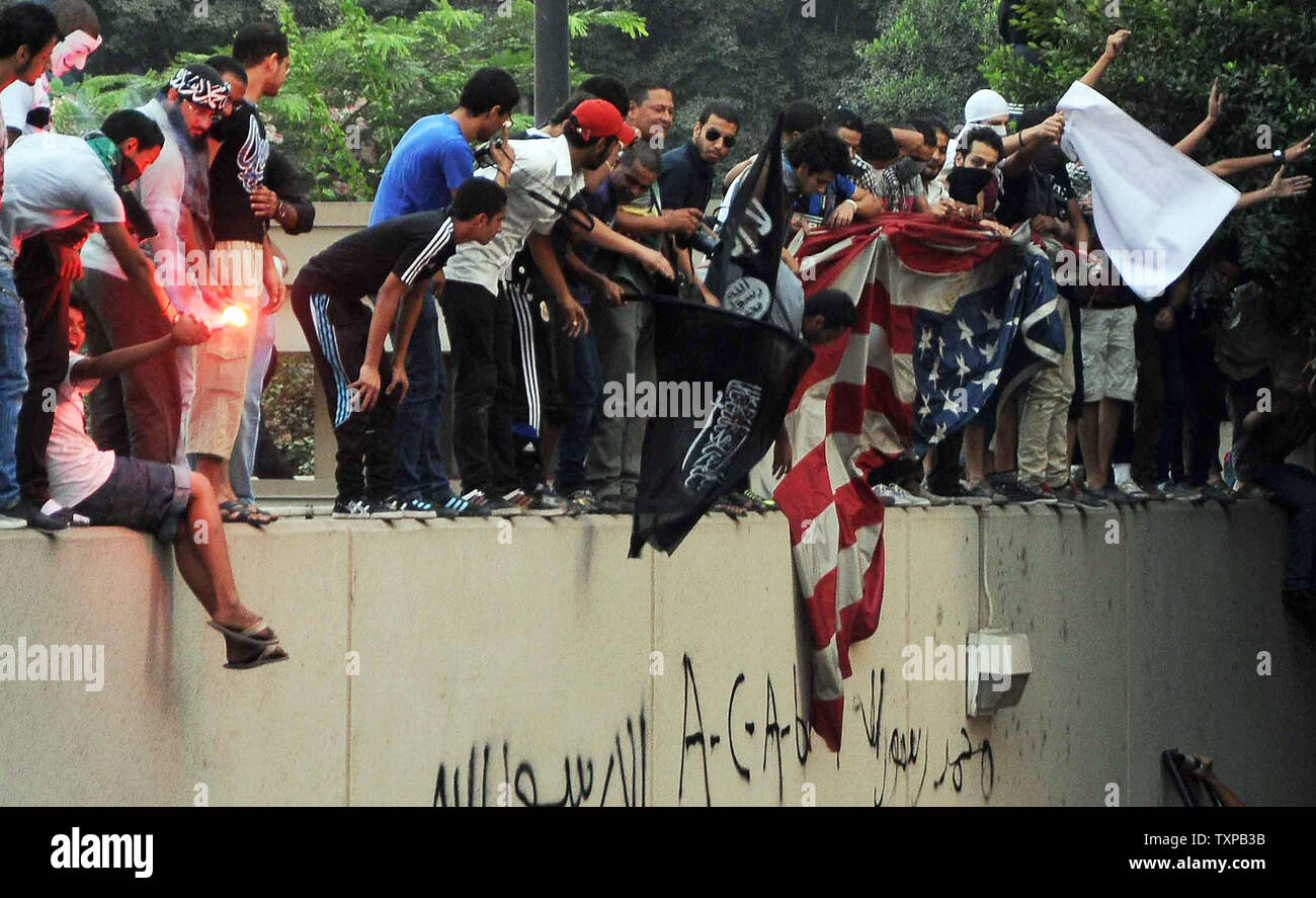 Egyptian protesters tear down an American flag at the United States embassy in Cairo on September 11, 2012, during a demonstration against a film deemed offensive to Islam and the Prophet Mohammad.  In Libya, Islamic extremists killed the American ambassador as they stormed the American consulate in Benghazi in anger against the little known film by an amateur American filmmaker.  UPI/Ahmed Jomaa Stock Photo